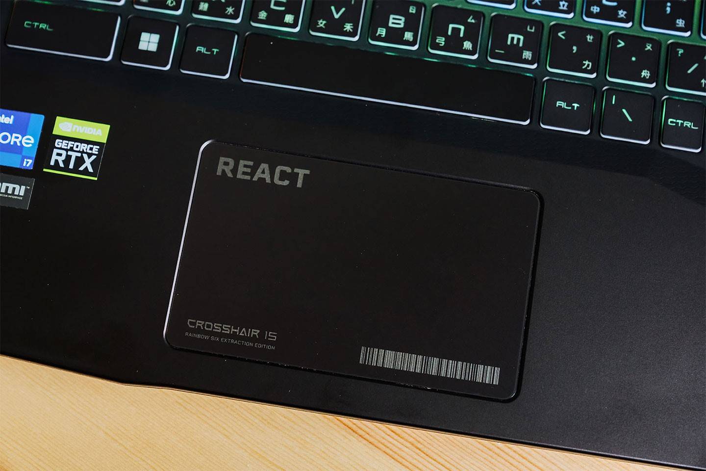 无键式的触控板在边角压印了 REACT 与 Crosshair 15 字样，搭配上二维条码整个很有游戏氛围。